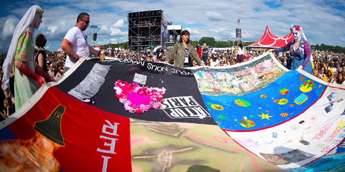 Un pan de patchwork des noms des mort-es du SIDA tenu par des activistes et des Soeurs de la Perpétuelle Indulgence