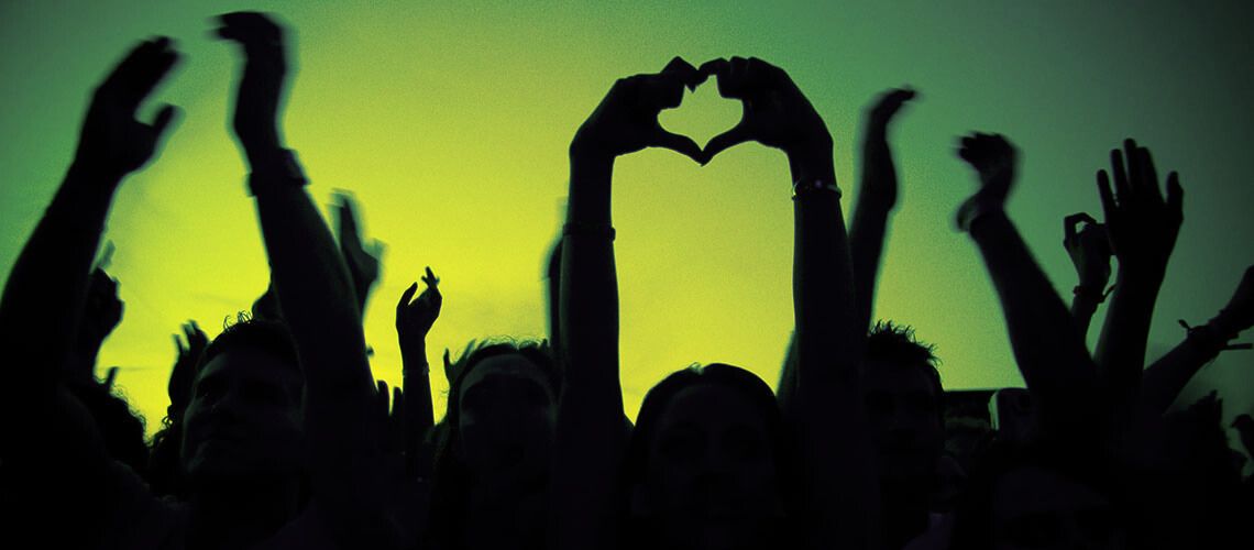 signe du coeur avec les mains dans la foule du public de soliays, fond vert